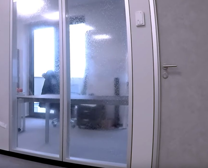 Porte vitrée de bureau avant pose du film : l'intérieur du bureau reste visible depuis le couloir