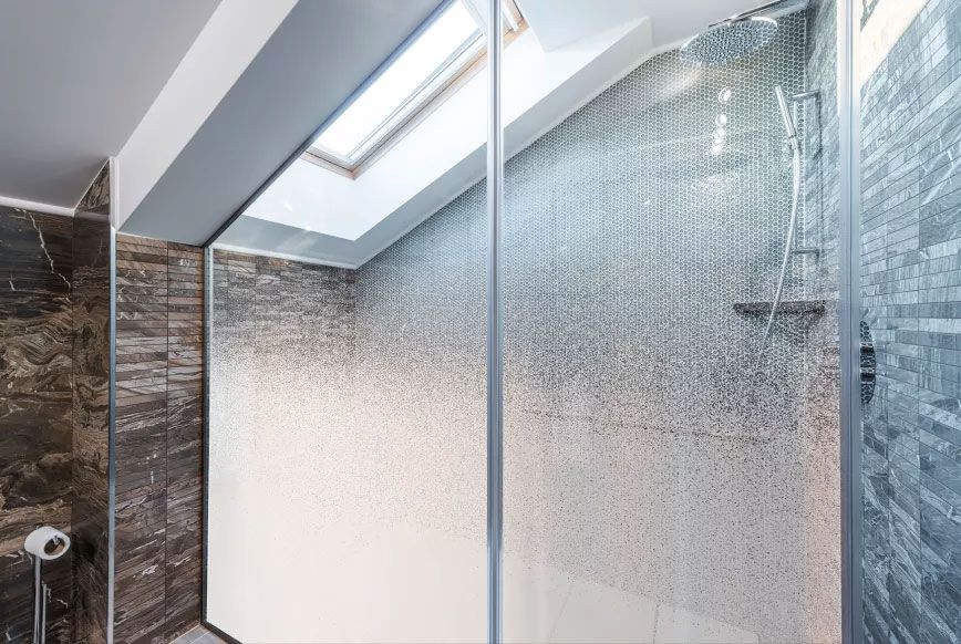 Parois vitrées d'une salle de bain habillées d'un film dégradé, dense en bas et plus clair vers le haut