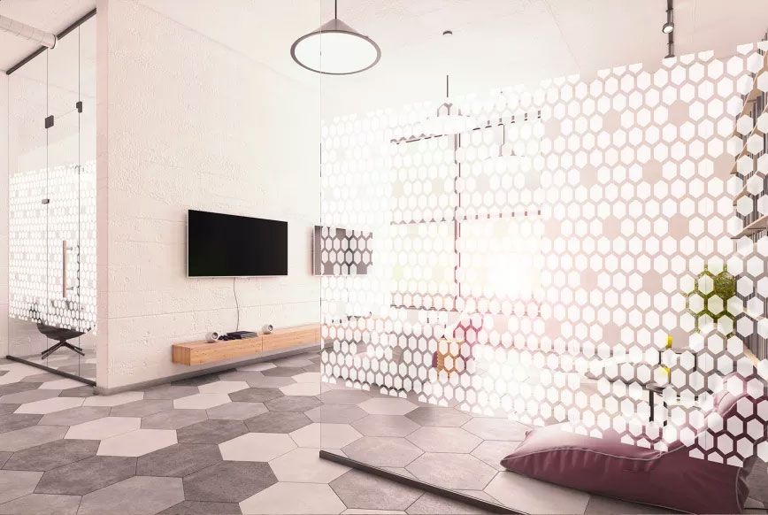 Cloison vitrée habillée d'un film décoratif à motif hexagonal blanc, dans un espace de détente