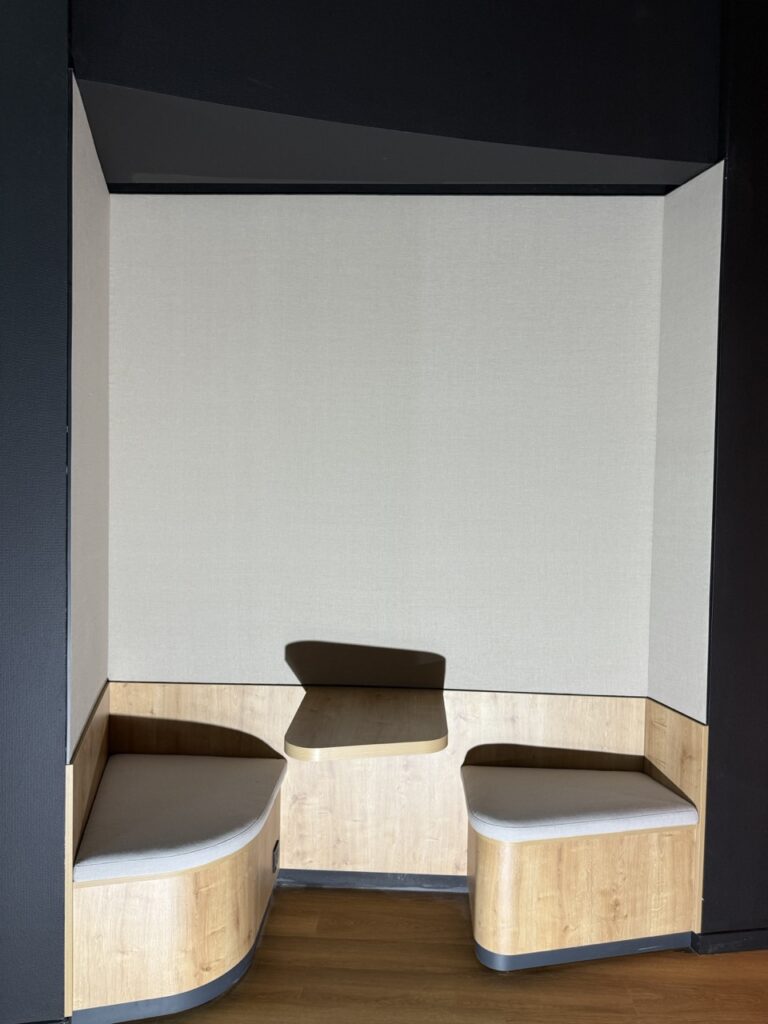 Bulle de réunion habillée de toile acoustique en lin, banquettes en bois, dans des bureaux à Lyon