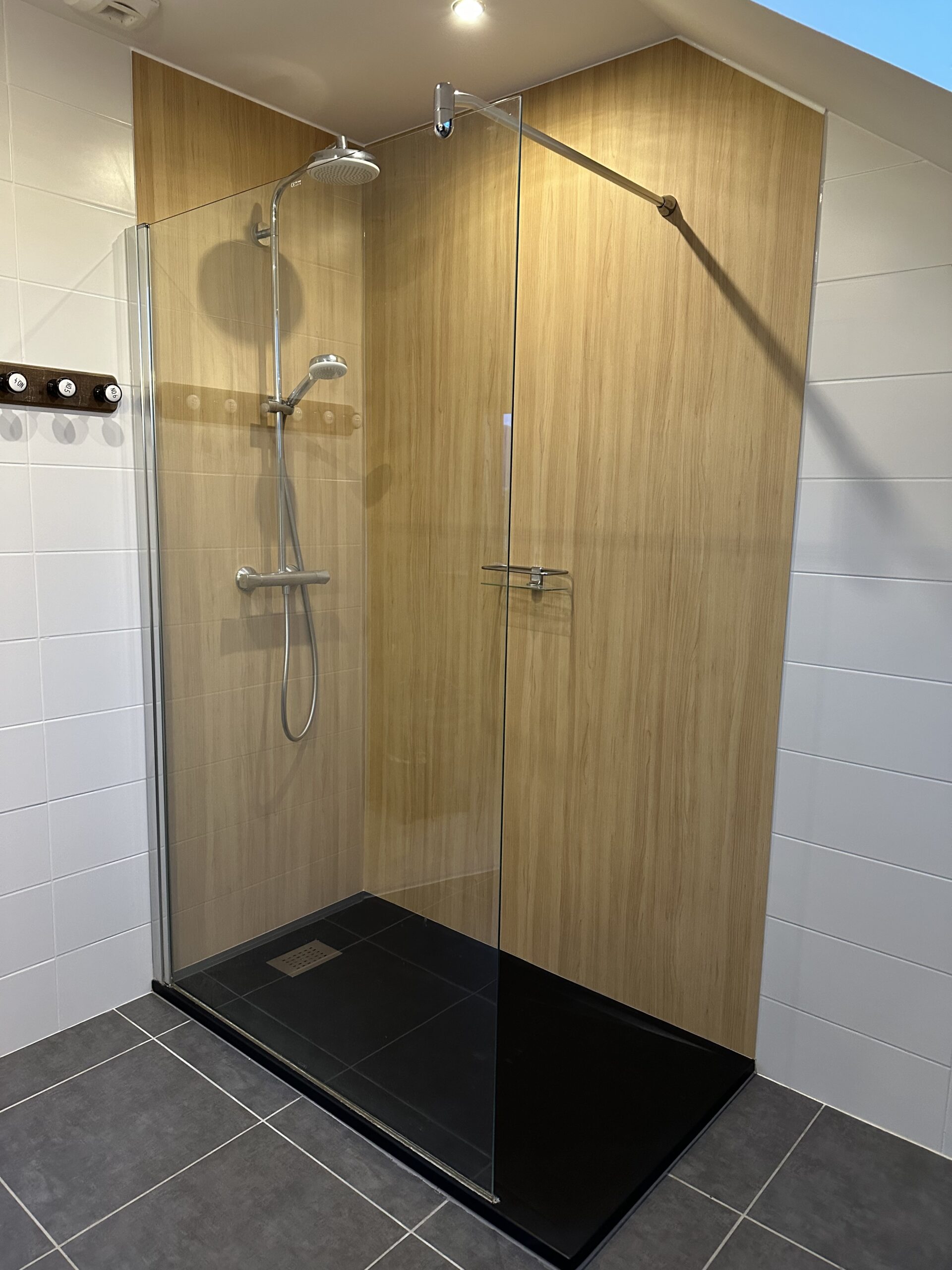 La même douche après habillage des parois en effet bois clair : les bandes de mosaïque ont disparu