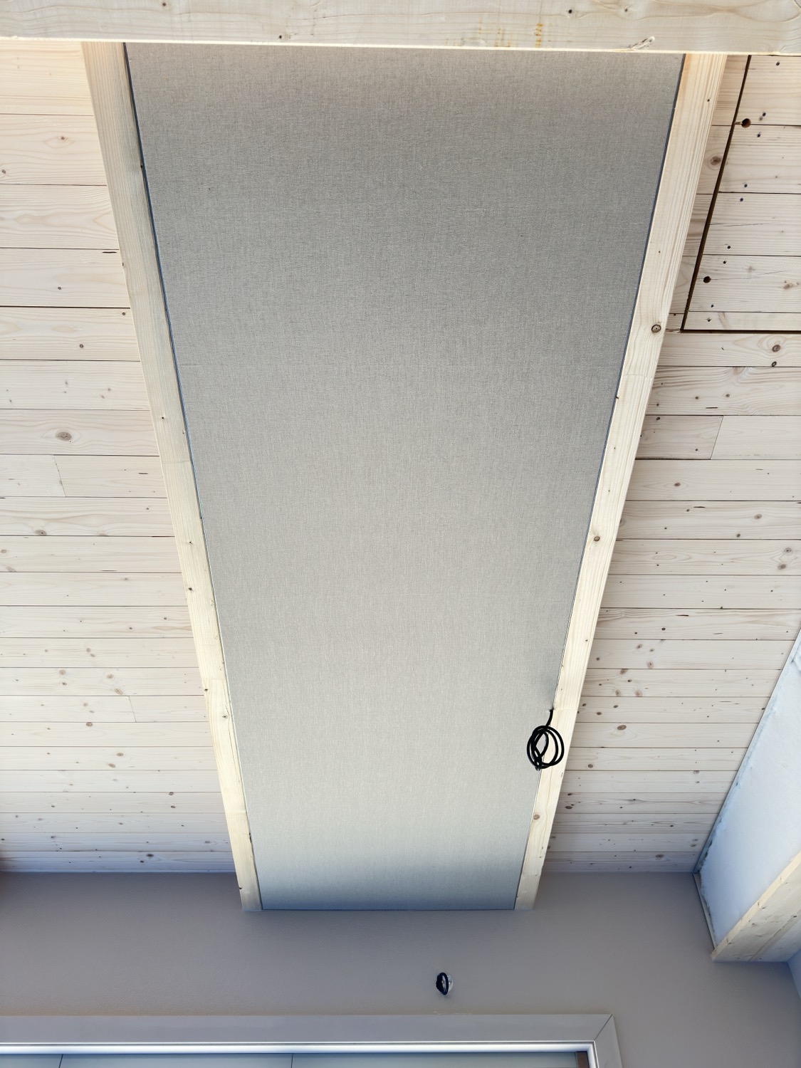 Le même plafond terminé : une toile de lin tendue gris clair recouvre entièrement le molleton