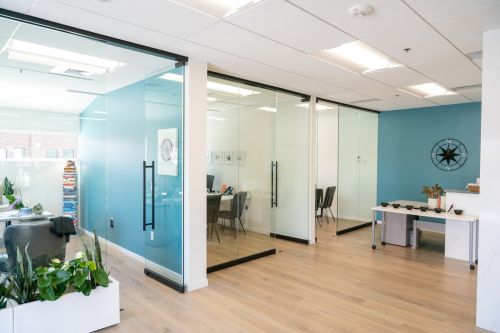 Open space de bureaux avec grandes vitres ensoleillées, protection solaire vitrage par film teinté bureau